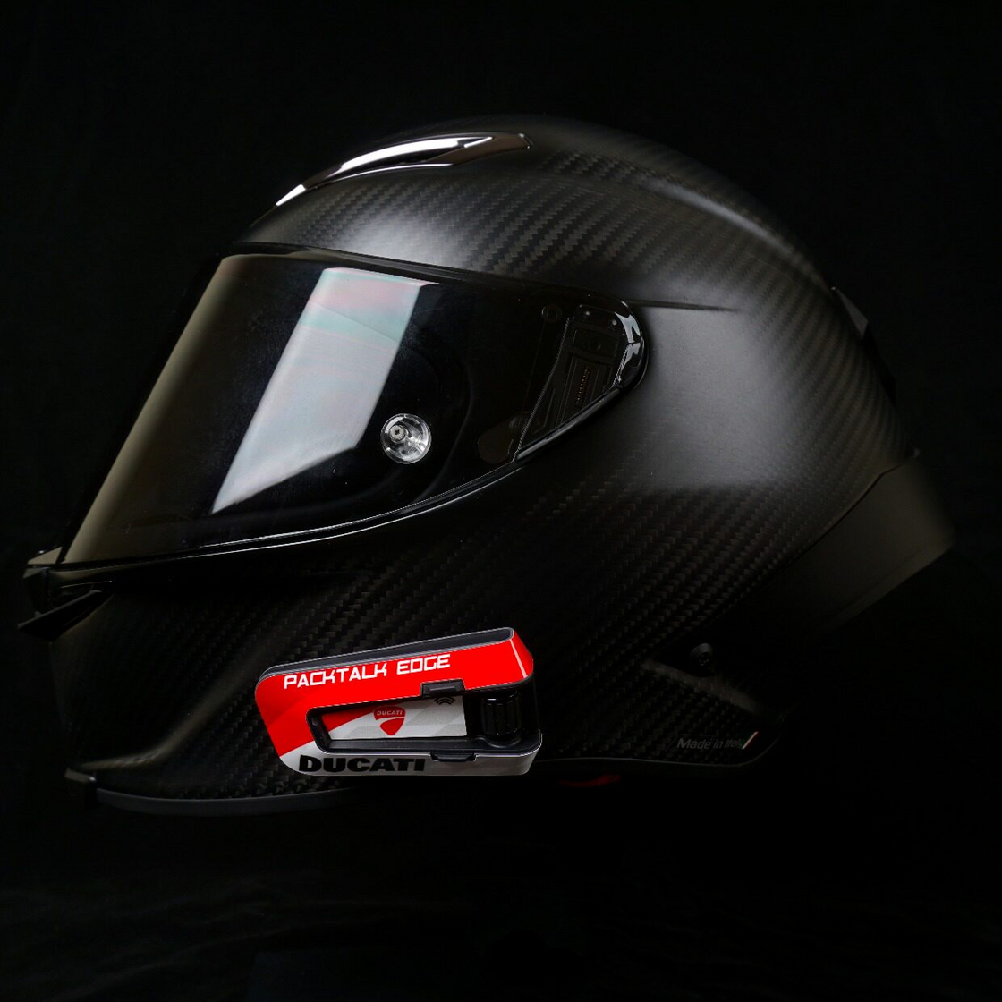Red and white decal on a PACKTALK EDGE communicator mounted to a helmet.